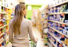 Biden’s Policies Starve Millions, IGNORE Food Solutions A woman pushing a shopping cart in a supermarket aisle filled with products
