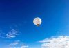 U.S. Military’s Secret Balloon Weapon Uncovered A white balloon floating in a clear blue sky with scattered clouds