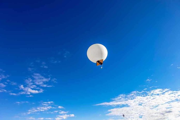 A white balloon floating in a clear blue sky with scattered clouds