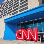 CNN Reporter CHOKES Live On Air Exterior view of the CNN headquarters with a large red logo and blue entrance