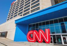 CNN Reporter CHOKES Live On Air Exterior view of the CNN headquarters with a large red logo and blue entrance