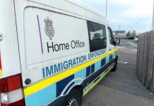 White immigration enforcement van parked by roadside