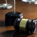Gavel and scales of justice on wooden table.