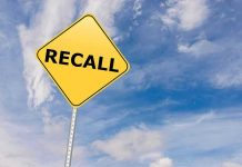 FIRE RISK Forces Mercedes MASS Recalls Yellow recall sign against blue, cloudy sky.