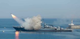 Warship firing missile in the sea.