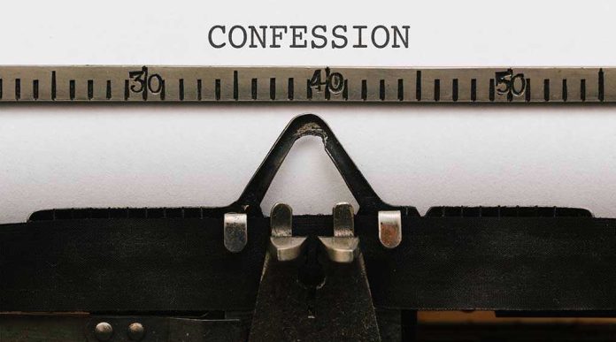 579321010 Typewriter typing the word confession on paper