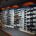 FORBIDDEN Database Contains SSNs of Gun Owners Wall-mounted guns displayed in a store.