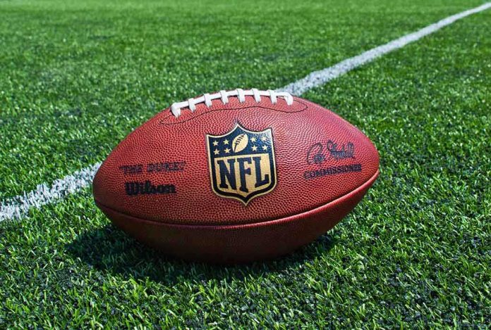 shutterstock_205708945.jpg An NFL football resting on a green grass field