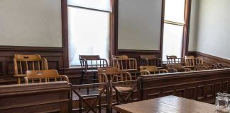 Empty jury box and table in courtroom.
