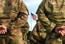 Promised Benefits REVOKED — Army Hit Hardest Soldiers stand in formation with American flag in background.