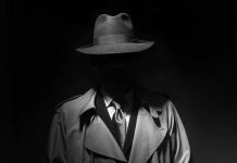 Blues Brother Murder Shocks Hermosa Beach Person in trench coat and fedora, face obscured by shadow.