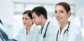Three medical professionals reviewing patient x-rays in a healthcare setting