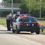 Police officer conducting a traffic stop on a highway