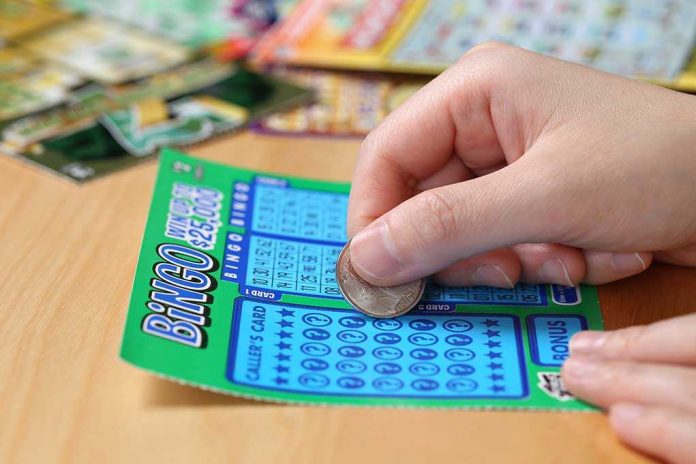 A person scratching off a bingo lottery ticket with a coin