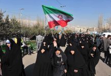 Iran Hangs Teen Wrestler After Protests Group of women in black attire marching with an Iranian flag