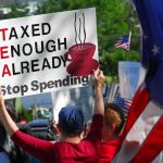 Tax Scheme BACKFIRES — Downtown Seattle Plummets Protesters holding signs against taxation at a political demonstration