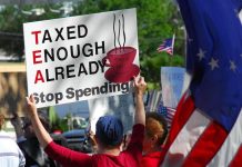 Protesters holding signs against taxation at a political demonstration