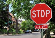 A red stop sign with the words STOP and ALL WAY in a residential area