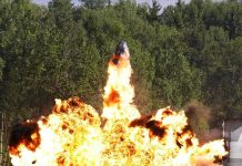 A large explosion with flames and smoke in an outdoor setting