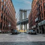ROOMMATE MURDERED — Body Hung From Bridge Street view with bridge between two brick buildings.