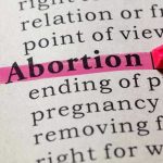 Teen Abortion Doula Training Sparks Uproar Abortion highlighted in a dictionary with a pink marker.