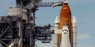 Astronaut Delivers Stunning Message 180,000 Miles Out Space shuttle on launch pad with support structure.