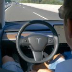 Person using autopilot in Tesla on highway.