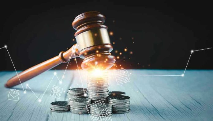 2094447643 Gavel, coins, and tax icons on a table.