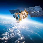 Satellite orbiting Earth with moon in background.