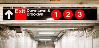 Subway exit sign indicating Downtown and Brooklyn with train numbers 1, 2, and 3