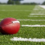 Married NFL Coach CAUGHT — Intimate Photos EXPOSED A red American football resting on a green artificial turf field