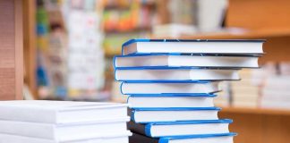 Tennessee Library Chief FIRED Over Books A stack of neatly arranged books on a wooden table in a bookstore