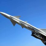 A military missile pointed upwards against a clear blue sky