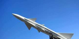 A military missile pointed upwards against a clear blue sky
