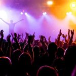 UK BANS Music Icon — Entire Festival DESTROYED Crowd at a concert with raised hands and colorful stage lights