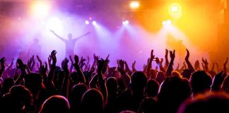 UK BANS Music Icon — Entire Festival DESTROYED Crowd at a concert with raised hands and colorful stage lights