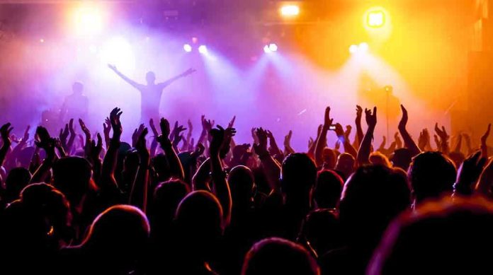 shutterstock_214402048.jpg Crowd at a concert with raised hands and colorful stage lights