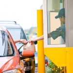 Customer receiving a food order at a drive-thru window