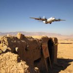 U.S. Warplanes Downed Over Iran Military aircraft flying over a desert with an abandoned bunker and a for sale sign