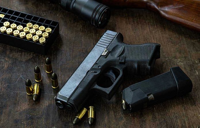 Handgun with ammunition, magazine, and rifle on wooden table.