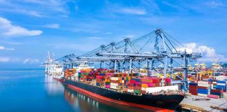 Court Says Tariffs Illegal — So Who Keeps the Cash? Container ship docked at a busy industrial port.