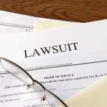 Cross-Burning Cash Trail Exposed! Documents labeled Lawsuit with glasses on top.