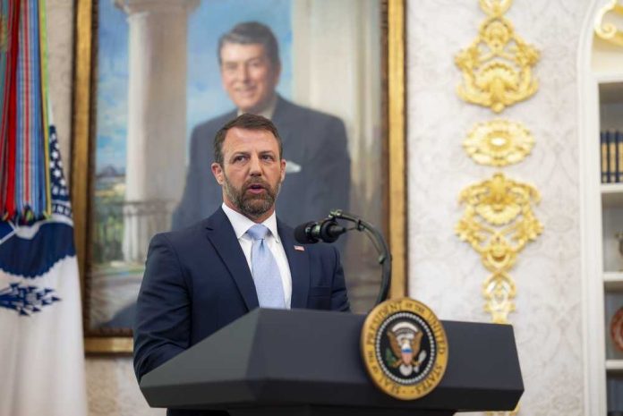 shutterstock_2767643921 Man in suit speaking at a podium in an ornate room