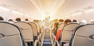 Mid-Flight Rage Over Sharia Law Claim airplane cabin with passengers seated in economy class
