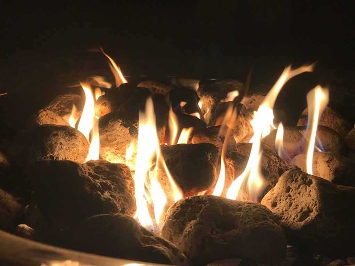 Fire pit flames over lava rocks at night