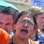 Woman with glasses shouting at a rally