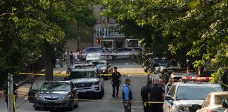 Hostage Horror Shocks Washington Police officers secure a residential street with patrol cars and yellow tape
