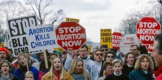 Federal Judge SMACKS Michigan Abortion Rule Protesters holding anti-abortion signs at a rally.