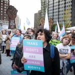 Protesters holding signs at a transgender rights rally