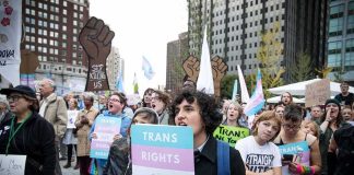 Protesters holding signs at a transgender rights rally